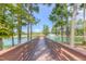 Picturesque pond view with a wooden pier, fountain, and tall trees creating a tranquil atmosphere at 428 Mill Station Ln, Wendell, NC 27591