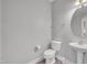 Simple half-bath featuring a pedestal sink, toilet, and light gray walls at 428 Mill Station Ln, Wendell, NC 27591