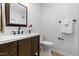 Powder room featuring a wooden vanity, quartz counters, and a toilet at 4349 Pickwick Dr, Raleigh, NC 27613