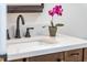 Close up of a bathroom vanity featuring quartz counters, and a pink flower accent at 4349 Pickwick Dr, Raleigh, NC 27613