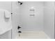Bathroom shower and bathtub combo featuring white tile and black fixtures at 4349 Pickwick Dr, Raleigh, NC 27613