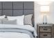 A close-up of the bedroom with a nightstand, lamp, pillows and comfortable bedding at 4349 Pickwick Dr, Raleigh, NC 27613