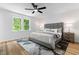 Bright bedroom boasts a plush bed, ceiling fan, and view of the outdoors from the window at 4349 Pickwick Dr, Raleigh, NC 27613