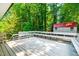 Spacious white deck with built-in bench seating overlooks the lush, green backyard and storage shed at 4349 Pickwick Dr, Raleigh, NC 27613