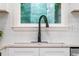 This kitchen features a sink with an attractive black faucet, white subway tiles, and a serene window view at 4349 Pickwick Dr, Raleigh, NC 27613