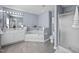 Well-lit bathroom with double vanity, bathtub, shower, and tile flooring at 4600 Landover Dale Dr, Raleigh, NC 27616