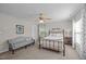 Comfortable bedroom featuring a ceiling fan, iron bed frame, and a cozy sitting area at 4600 Landover Dale Dr, Raleigh, NC 27616