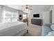Bright bedroom with large windows, ceiling fan, TV, dresser, and a sitting area at 4600 Landover Dale Dr, Raleigh, NC 27616