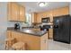 Bright kitchen offers ample counter space, wood cabinets, black appliances, and breakfast bar seating at 4600 Landover Dale Dr, Raleigh, NC 27616