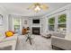 Comfortable living room with a fireplace, wall-mounted TV, and large windows for natural light at 4600 Landover Dale Dr, Raleigh, NC 27616