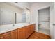 Bright bathroom featuring a double sink vanity with wood cabinets and a shower with accessibility features at 4622 Ivy Blossom Ln, Raleigh, NC 27604