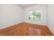 Bedroom featuring hardwood floors, a large window with blinds and white trim at 4622 Ivy Blossom Ln, Raleigh, NC 27604