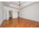 Spacious bedroom with tray ceiling, wood floors, and multiple doors at 4622 Ivy Blossom Ln, Raleigh, NC 27604