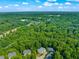 Aerial view of suburban homes surrounded by a dense, lush forest on a sunny day at 4831 Crestmore Rd # 202, Raleigh, NC 27612