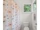 Full bathroom featuring white tile, a window for natural light, and a floral shower curtain at 4831 Crestmore Rd # 202, Raleigh, NC 27612