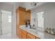 Bathroom featuring wood cabinets, white countertops, and a large mirror over the sink at 4831 Crestmore Rd # 202, Raleigh, NC 27612