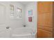 Bright bathroom featuring a soaking tub under a window, plus a linen cabinet at 4831 Crestmore Rd # 202, Raleigh, NC 27612
