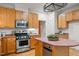 Kitchen featuring wooden cabinets, stainless steel appliances, and an island with a countertop at 4831 Crestmore Rd # 202, Raleigh, NC 27612