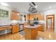 Kitchen with stainless steel appliances, hardwood floors, and an island with a hanging pot rack at 4831 Crestmore Rd # 202, Raleigh, NC 27612