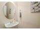 Powder room featuring a round mirror and a floating sink with modern fixtures at 4831 Crestmore Rd # 202, Raleigh, NC 27612