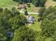 Aerial view of a home nestled among trees, with open fields and farmhouses nearby at 4880 Old Us Hwy 64, Zebulon, NC 27597