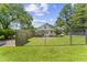 A spacious backyard featuring a chain-link fence, green grass, and mature trees at 4880 Old Us Hwy 64, Zebulon, NC 27597