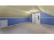 Blue bedroom with yellow ceiling, small door, and access to hallway, all carpeted at 4880 Old Us Hwy 64, Zebulon, NC 27597
