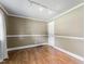 A bright bedroom with wood-look flooring, neutral wainscoting, and a track lighting fixture at 4880 Old Us Hwy 64, Zebulon, NC 27597