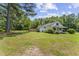 Exterior shot of home highlighting the yard, porch, and mature trees at 4880 Old Us Hwy 64, Zebulon, NC 27597