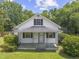 Charming white home featuring a covered front porch, black shutters, and beautifully maintained landscaping at 4880 Old Us Hwy 64, Zebulon, NC 27597