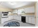 Efficient kitchen with white cabinets, black appliances, and durable flooring at 4880 Old Us Hwy 64, Zebulon, NC 27597