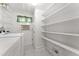 Laundry room with shelving, white appliances, and window AC unit, offering practical storage at 4880 Old Us Hwy 64, Zebulon, NC 27597