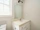 Bathroom with a modern toilet, sink, mirror, and a window for natural lighting at 505 Commander Dr, Wendell, NC 27591