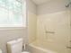 Bright bathroom features a tub-shower combination, toilet and window with natural light at 505 Commander Dr, Wendell, NC 27591