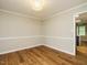 Well-lit dining room with wood-style floors, crown molding, and a classic light fixture at 505 Commander Dr, Wendell, NC 27591