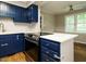 A well-lit kitchen showcasing blue cabinets, a white countertop island, and modern stainless steel appliances at 505 Commander Dr, Wendell, NC 27591