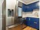 A detailed view of a kitchen with stainless steel refrigerator and blue cabinets, showcasing its modern design at 505 Commander Dr, Wendell, NC 27591