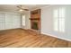 Spacious living room with a brick fireplace, built-in shelving, and wood-style floors at 505 Commander Dr, Wendell, NC 27591
