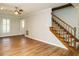 Open-concept living room with wood-style floors and a staircase with wood banister at 505 Commander Dr, Wendell, NC 27591