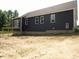 Rear exterior view showcasing the dark siding, patio doors, and the home's fresh construction at 53 Stonewood Loop Ln, Henderson, NC 27537