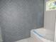 Elegant bathroom showing a herringbone-patterned wall, soaking tub, and natural light from a window at 53 Stonewood Loop Ln, Henderson, NC 27537