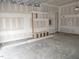 A spacious garage, ready for customization, including shelving unit and ample storage space at 53 Stonewood Loop Ln, Henderson, NC 27537