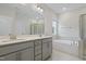 A full bathroom featuring double sinks, a large mirror, soaking tub, and glass enclosed shower at 544 Tanner Lake Ln, Raleigh, NC 27610