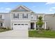 Charming two-story home with gray siding, stone accents, and a well-manicured lawn and a two car garage at 544 Tanner Lake Ln, Raleigh, NC 27610