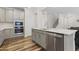 Modern kitchen features stainless appliances, gray cabinets, and a center island with a sink at 544 Tanner Lake Ln, Raleigh, NC 27610