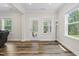 Bright living room with wood floors, two windows, and a glass door leading to outdoor area at 544 Tanner Lake Ln, Raleigh, NC 27610