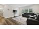 Cozy living room with a large black leather couch, decorative rug, and a view through the windows at 544 Tanner Lake Ln, Raleigh, NC 27610