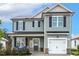 Charming two-story home featuring light gray siding and a welcoming front porch with chairs at 553 Sturgeon St, Smithfield, NC 27577