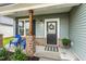 Close-up of a charming front porch with a door wreath, blue chairs, and brick accents at 553 Sturgeon St, Smithfield, NC 27577