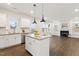 Kitchen featuring granite countertops, stainless steel appliances, and an island that opens to the living room with fireplace at 553 Sturgeon St, Smithfield, NC 27577